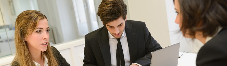 three professionals discussing legal advice in an office setting