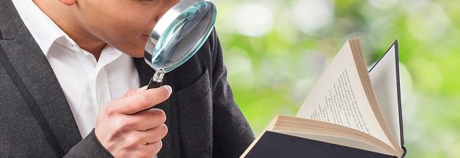 person examining evidence through magnifying glass