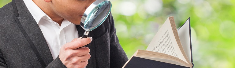 person examining evidence through magnifying glass