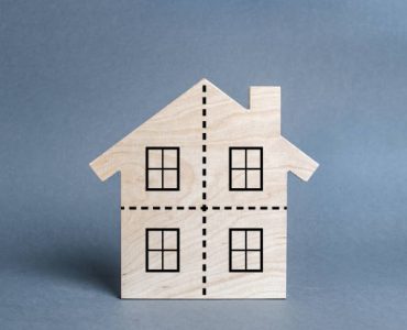 Residential building divided by a dotted line into four equal parts. Divorce concept. Disputes over division process of real estate and property after divorce. Distribution of the right